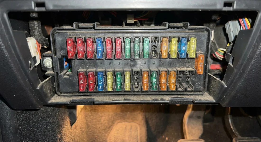 Plan rapproché de la boîte à fusibles de l'habitacle d'une Peugeot 206.